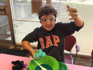 Kid in process of mixing slime