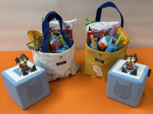 Kids prize bags for Library Card Sign-Up Month include a Toniebox player, squeeze toy, game and chocolate